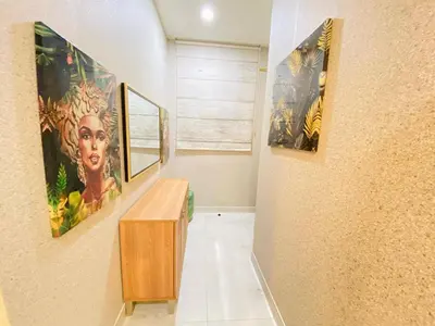 a hallway with paintings on the wall and a wooden table at Dubai Luxury Apartments In a good place in Dubai