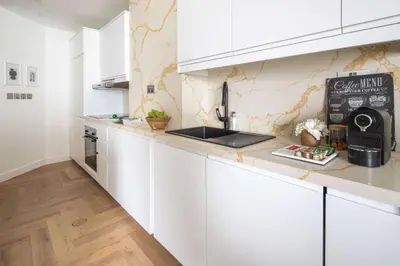 a kitchen with white cabinets and a counter top at Frank Porter - Torch Tower in Dubai