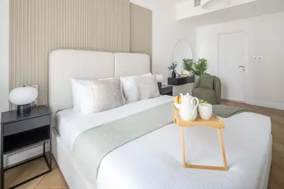 a bedroom with a white bed with a wooden table at Frank Porter - Torch Tower in Dubai