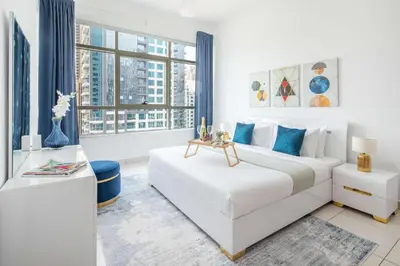 a white bedroom with a bed and a large window at Frank Porter - Marina Views in Dubai