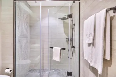 a shower with a glass door in a bathroom at Two Bedroom Apartment in Nobles Tower by The S Holiday Homes in Dubai