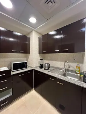 a kitchen with dark brown cabinets and a sink at New 1BED Apartment in Remraam, Dubai Land, Motor city, Damac hills, Mudoon area in Dubai