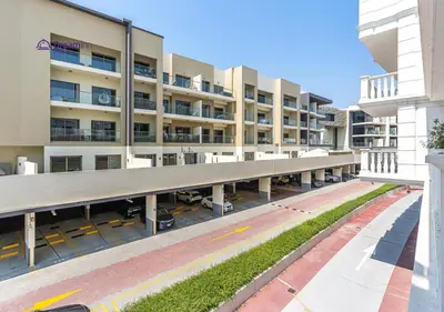 an empty parking lot in front of a building at Dream Inn - Modern 1BR in Arjan in Dubai