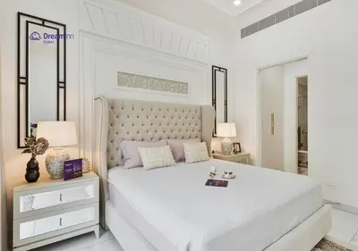 a white bedroom with a large bed and two lamps at Dream Inn - Modern 1BR in Arjan in Dubai