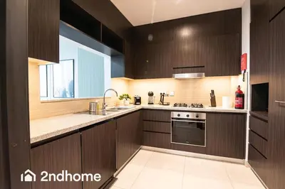 a kitchen with wooden cabinets and a sink and a stove at Downtown Views 1 - Direct Access to Dubai Mall in Dubai
