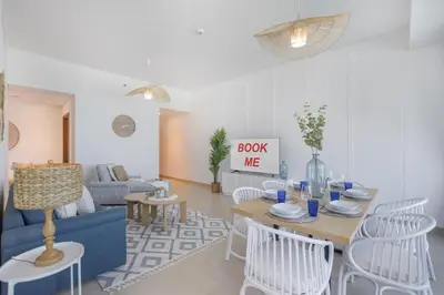 a living room with a blue couch and a table and chairs at StayShort - Elegant 2BR in Dubai Marina - Luxury Awaits You in Dubai