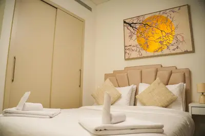 a bedroom with a bed with two towels on it at Vserve 2BR Perfect Blend of Luxury Comfort & Convenience in Dubai