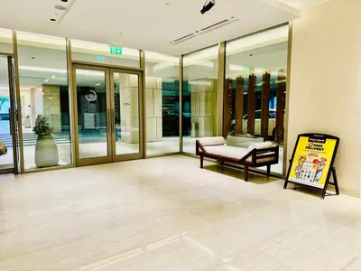 a lobby with a bench and a sign in a building at Vserve 2BR Perfect Blend of Luxury Comfort & Convenience in Dubai