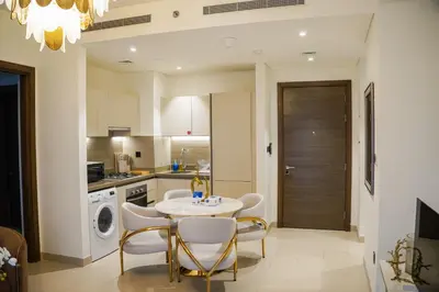 a kitchen with a table and chairs in a room at Vserve 2BR Perfect Blend of Luxury Comfort & Convenience in Dubai