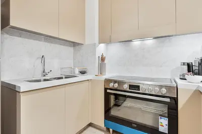 a kitchen with a stove and a sink at Chic 1BR APT with Pool, Gym & Kid's Playground in Dubai