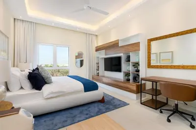 a bedroom with a bed and a desk and a deskablish at Renovated Studios in Nature at Discovery Gardens in Dubai