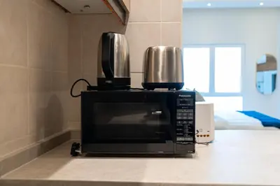 a microwave with two cups on top of it at Renovated Studios in Nature at Discovery Gardens in Dubai