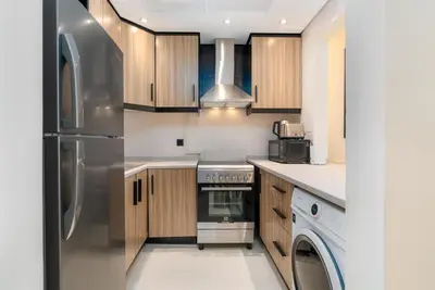 a kitchen with wooden cabinets and a stainless steel refrigerator at Renovated Studios in Nature at Discovery Gardens in Dubai