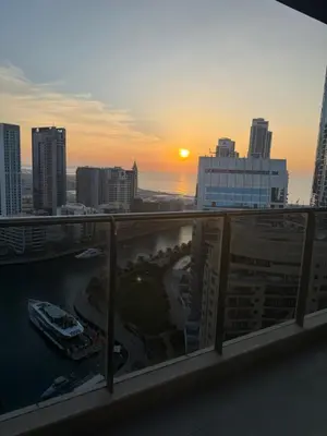 a view of the sunset from the balcony of a building at Sparkle Towers by Swarovski - Dubai Marina - High Floor - Beach Resort Sunset view in Dubai