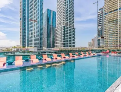 a large swimming pool with lounge chairs in a city at ZenStay - Haven of tranquility and luxury in Dubai