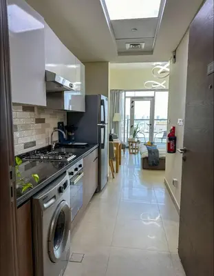 a kitchen with a stove and a washer and dryer at Vibrant studio - 15m to marina in Dubai