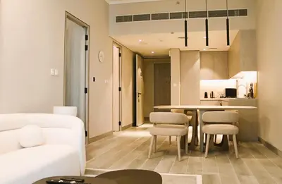 a living room and kitchen with a table and chairs at Casa Royale Vacation Home - JVC in Dubai