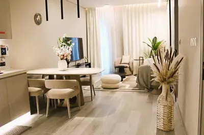 a kitchen and living room with a table and chairs at Casa Royale Vacation Home - JVC in Dubai