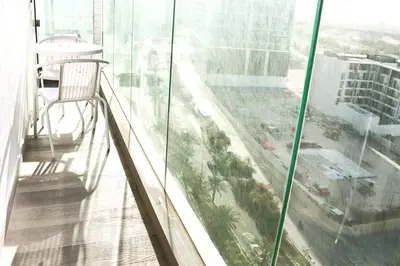 a balcony with a chair and a view of a city at Casa Royale Vacation Home - JVC in Dubai