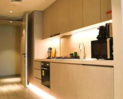 a kitchen with a refrigerator and a stove top oven at Casa Royale Vacation Home - JVC in Dubai