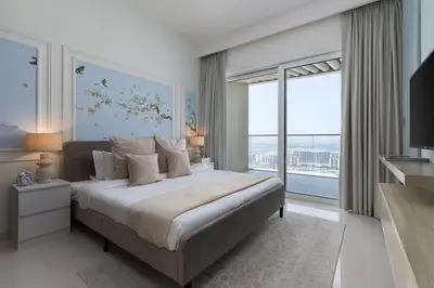 a bedroom with a large bed and large windows at Maison Privee - Waterfront Living with Unparalleled Sea & Palm Vws in Dubai