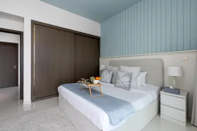 a bedroom with a large bed with a table on it at Maison Privee - Waterfront Living with Unparalleled Sea & Palm Vws in Dubai