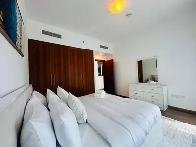 a bedroom with a large white bed with white pillows at Airvistas Elevate Living 1BHK in Dubai