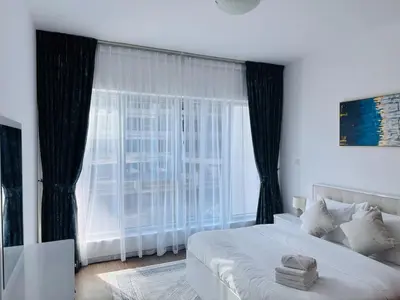a bedroom with a bed and a large window at Airvistas Elevate Living 1BHK in Dubai