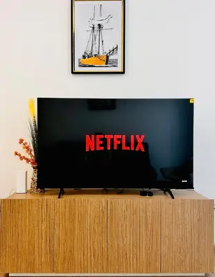 a flat screen tv sitting on top of a wooden cabinet at Airvistas Elevate Living 1BHK in Dubai