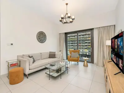 a living room with a couch and a tv at Stylish 3BR in BurjCrown Balcony & HighEnd Comfort in Dubai