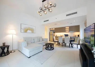 a living room with a couch and a dining room at Upscale2BR in Burj Crown Pool,Gym & Stunning Views in Dubai