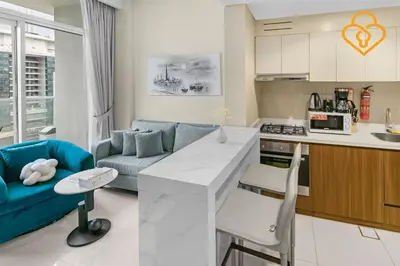 a kitchen and living room with a blue couch at Keysplease 1 BR Apt, Vera Residence Business Bay in Dubai