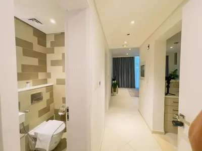 a bathroom with a toilet and a hallway at Vserve Comfy & Relaxing 1 BDR Retreat At the Palm in Dubai