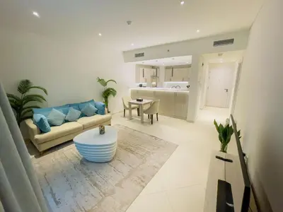 a living room with a couch and a table at Vserve Comfy & Relaxing 1 BDR Retreat At the Palm in Dubai