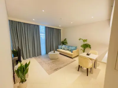 a living room with a couch and a table at Vserve Comfy & Relaxing 1 BDR Retreat At the Palm in Dubai