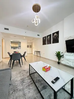 a living room with a table and a couch at Large 1BR Apartment with Balcony in JVC - JLiving in Dubai