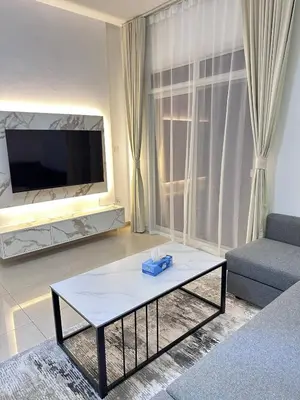 a living room with a tv and a couch and a table at Large 1BR Apartment with Balcony in JVC - JLiving in Dubai