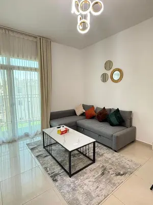 a living room with a couch and a coffee table at Large 1BR Apartment with Balcony in JVC - JLiving in Dubai