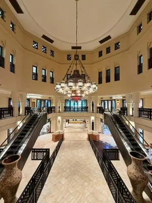an empty lobby with a chandelier in a building at Souk Al Bahar Luxury stays near poolside with Burj Khalifa view by Norbu Holiday Homes in Dubai