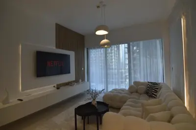 a living room with a large couch and a tv at Luxury 1BR Apt Best view Infinity Pool Burj Khalifa with Balcony in Dubai