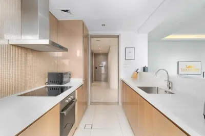 a kitchen with white counter tops and a sink at Damac Paramount Tower Burj Views in Dubai