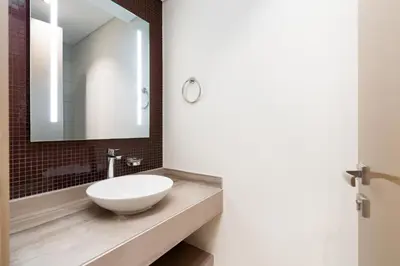 a bathroom with a white sink and a mirror at Damac Paramount Tower Burj Views in Dubai