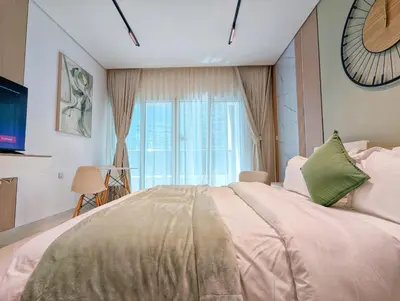 a bedroom with a large bed with a large window at Waterfront Studio with Burj Khalifa & Dubai Mall Access, Walk to Dubai Water Canal & Business Bay Metro in Dubai