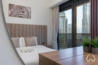 a hotel room with a bed and a large window at Luxurious 4BR In Act 1 Act 2 With Burj Khalifa View in Dubai