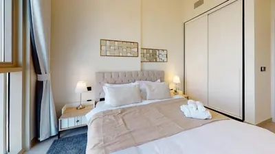 a bedroom with a large white bed and two lamps at Tranquil Oasis 2BR at Collective Dubai Hills in Dubai