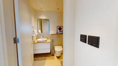 a bathroom with a sink and a toilet and a mirror at Tranquil Oasis 2BR at Collective Dubai Hills in Dubai