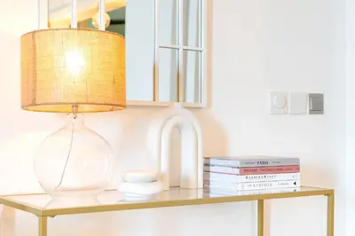 a table with a lamp and books on it at BURJ views Private Beach 2 Bedroom Apartment with panoramic Sea View and Pool Palm Jumeirah in Dubai