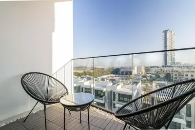 two chairs on a balcony with a view of a city at GuestReady - Modern living in JVC in Dubai