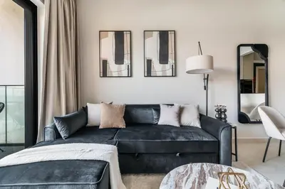 a living room with a black couch and mirrors at GuestReady - Modern living in JVC in Dubai