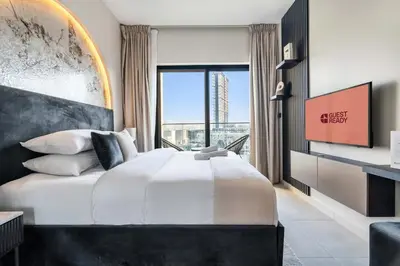 a bedroom with a large bed and a large window at GuestReady - Modern living in JVC in Dubai